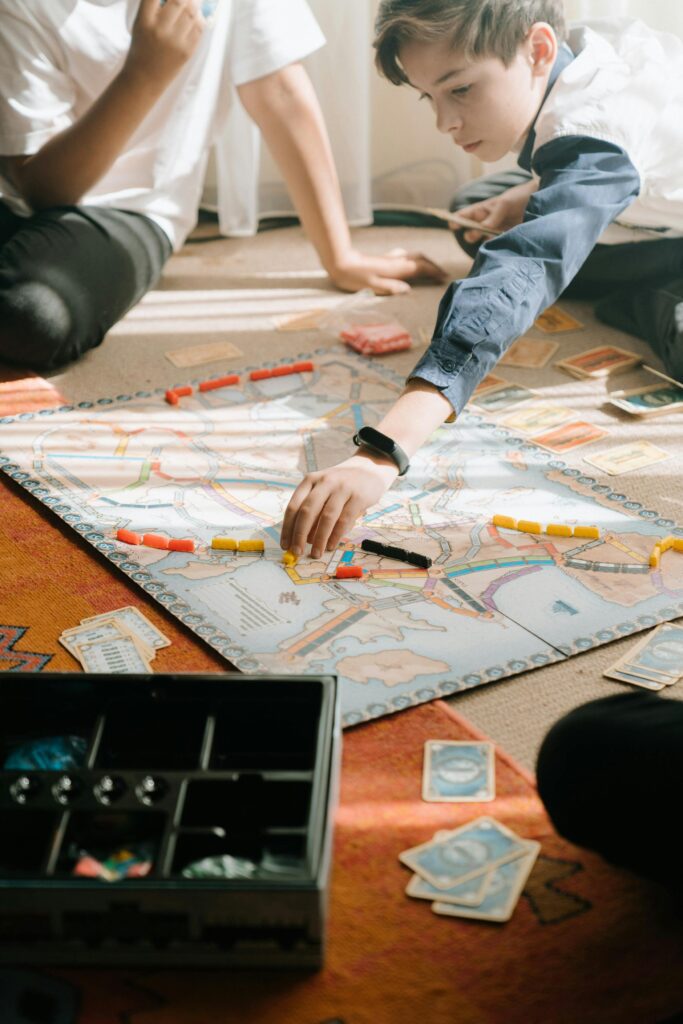 Kids enjoy strategy and teamwork playing a euro-style board game indoors.